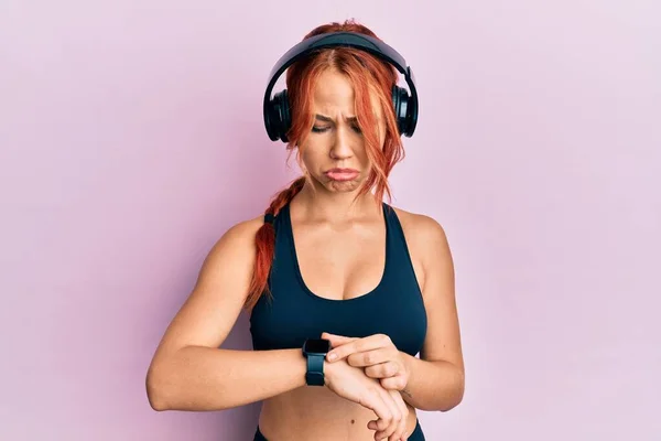 Young Beautiful Redhead Woman Wearing Gym Clothes Using Headphones Smart — Foto de Stock