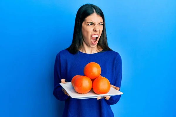 Junge Hispanische Frau Hält Teller Mit Frischen Orangen Wütend Und — Stockfoto