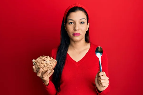Jonge Latijnse Vrouw Met Cornflakes Lepel Ontspannen Met Serieuze Uitdrukking — Stockfoto