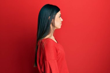 Latin kökenli genç bir kadın rahat bir görünüm ve kendine güvenen bir gülümseme takınıyor.. 