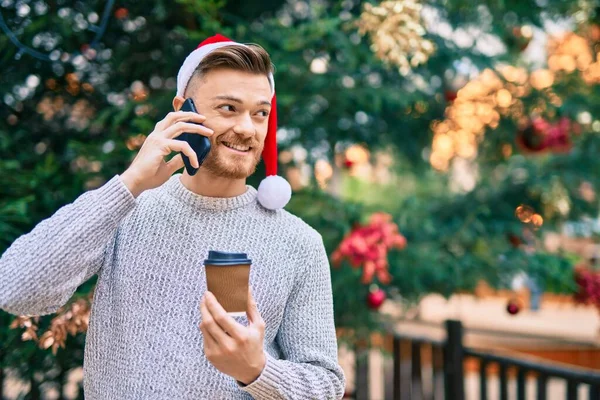 Νεαρός Καυκάσιος Που Φοράει Χριστουγεννιάτικο Καπέλο Μιλάει Στο Smartphone Και — Φωτογραφία Αρχείου