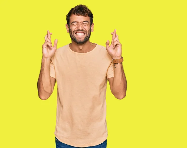 Bonito Jovem Com Barba Vestindo Camiseta Casual Gesto Dedo Cruzado — Fotografia de Stock