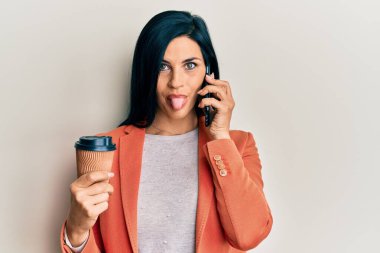 Kafkas 'lı genç bir kadın elinde akıllı telefonla konuşuyor kahveyi götürüyor dilini dışarı çıkarıyor ve komik bir ifadeyle mutlu oluyor.. 