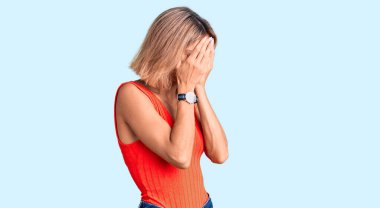 Güzel, beyaz bir kadın. Günlük kıyafetler giyiyor. Ağlarken suratını ellerle kapatıyor. depresyon kavramı. 