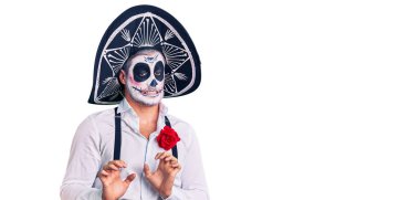 Arka planda ölü kostümü giymiş bir adam tiksindirici bir ifade takınıyor ve tiksindirici bir yüz ifadesi takınıyor.. 