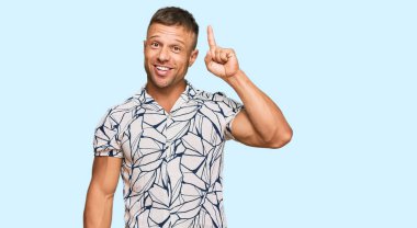 Sıradan giyinen yakışıklı kaslı adam başarılı bir fikirle işaret ediyor. Heyecanlı ve mutlu. Bir numara.. 