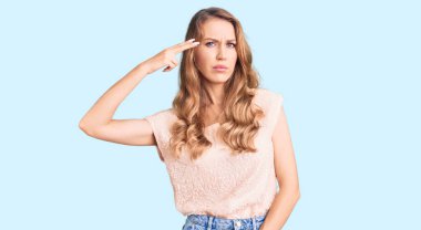 Sarışın, güzel, beyaz bir kadın. Sıradan kıyafetler giyiyor. Silah gibi elini ve parmaklarını havaya kaldırarak ateş ediyor.. 