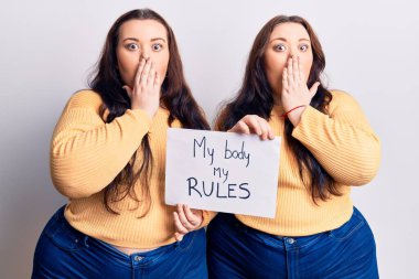 Genç ve beden ölçülerinde ikizler vücudumu tutuyor. Benim kurallarıma göre pankartım ağzı elle kapatıyor, şok geçiriyor ve hata yapmaktan korkuyor. şaşırmış ifade 