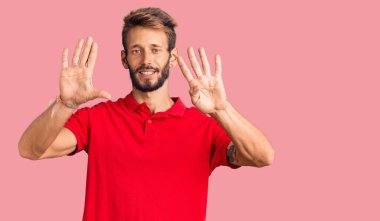 Yakışıklı, sakallı, sıradan kıyafetler giyen, dokuz numaralı parmaklarıyla işaret eden, kendinden emin ve mutlu bir adam.. 