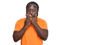 Sıradan kıyafetler giyen yakışıklı Afro-Amerikan erkeği ağzını yanlışlıkla ellerle kapatırken şok oldu. gizli kavram. 