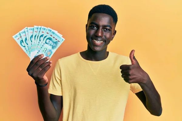 Fiatal Afro Amerikai Férfi Kezében Jüan Kínai Bankjegyek Mosolyogva Boldog — Stock Fotó