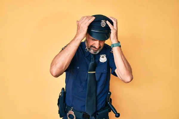 中年惊慌失措的男子身穿警服 由于疼痛和偏头痛而陷入绝望和压力 手放在头上 — 图库照片