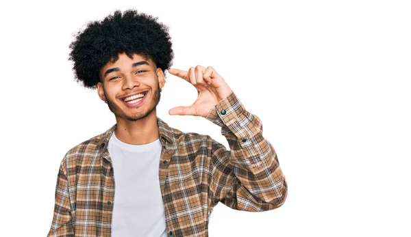 年轻的非洲裔美国人 留着黑头发 穿着休闲装 面带微笑 手拿着小尺寸的标志 手拿着相机 自信地摆姿势 计量概念 — 图库照片