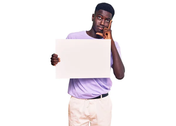 Jovem Afro Americano Segurando Banner Vazio Vazio Rosto Sério Pensando — Fotografia de Stock