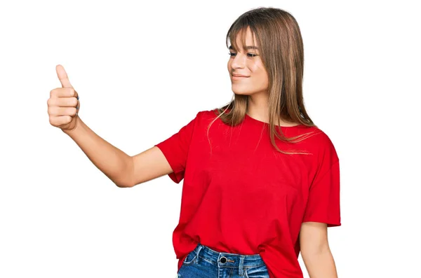ティーンCaucasian女の子身に着けていますカジュアル赤Tシャツ見誇りに思って 笑顔行います親指アップジェスチャーへザ側 — ストック写真