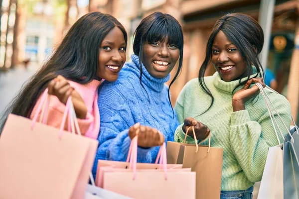 Three african american friends going shopping at the city.