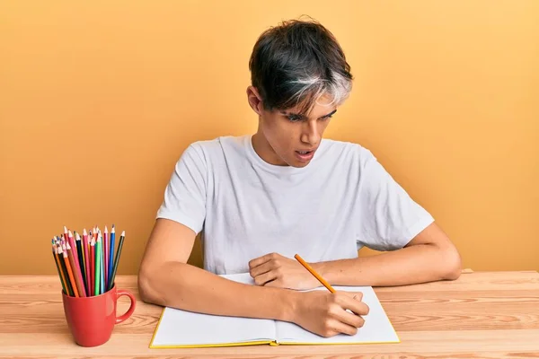 Young Hispanic Man Writing Book Sitting Table Afraid Shocked Surprise — Stock Photo, Image