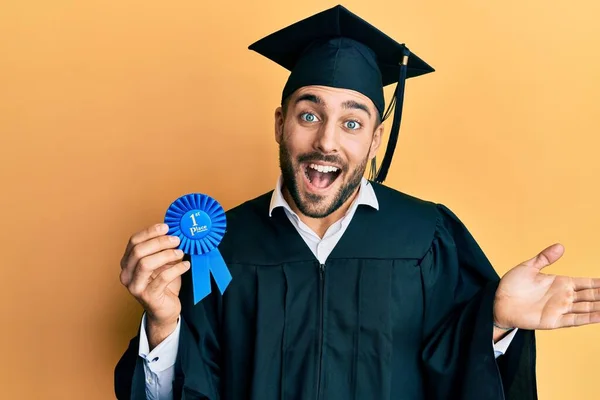 Joven Hombre Hispano Usando Bata Graduación Sosteniendo Insignia Del Primer — Foto de Stock