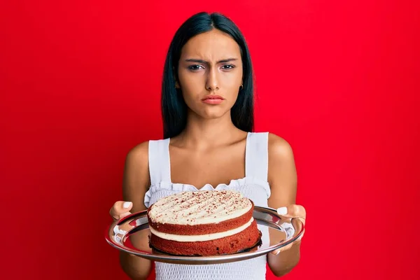 Young Brunette Woman Holding Carrot Cake Skeptic Nervous Frowning Upset — Stock Photo, Image