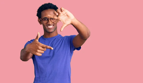 カジュアルな服や眼鏡を身に着けているアフリカのハンサムな男は幸せな顔で手や指でフレームを作り笑顔 創造性と写真の概念 — ストック写真