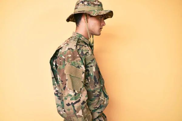 若いですハンサムな男身に着けていますカモフラージュ軍制服横に見て 自信を持って笑顔で自然な顔でプロファイルポーズをリラックス — ストック写真