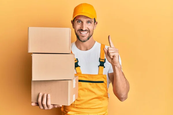 Young Handsome Delivery Man Holding Packages Smiling Idea Question Pointing — Stock Photo, Image