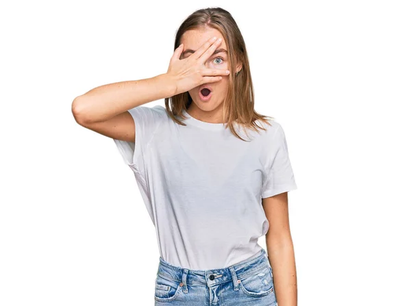Hermosa Joven Rubia Vistiendo Casual Camiseta Blanca Asomándose Shock Cubriendo —  Fotos de Stock