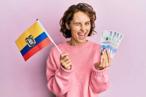 年轻的黑发女人拿着科洛姆比亚国旗和科洛姆比亚比索钞票眨眼看着摄像机 脸上带着性感的表情 笑容满面 — 图库照片