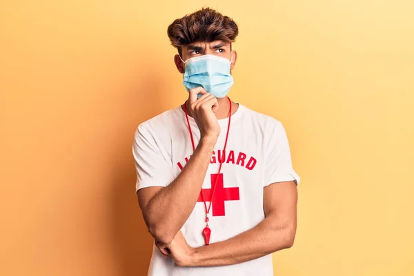 Joven Hombre Hispano Con Camiseta Salvavidas Usando Máscara Médica Pensando —  Fotos de Stock