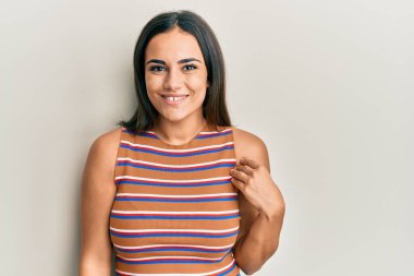 Genç esmer kadın mutlu ve havalı bir gülümsemesi olan günlük kıyafetler giyiyor. şanslı kişi. 