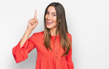 Gündelik kıyafetler giyen genç ve güzel bir kadın başarılı bir fikirle işaret ediyor. Heyecanlı ve mutlu. Bir numara.. 