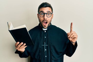 Genç İspanyol rahip elinde İncil 'le korku ve şaşkınlık dolu bir ifade, korku ve heyecan dolu bir yüz tutuyor.. 