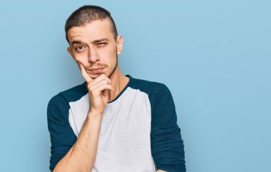 İspanyol genç adam günlük kıyafetler giyip kollarını kavuşturarak depresyondan sıkılmış ve yorgun görünüyor.. 