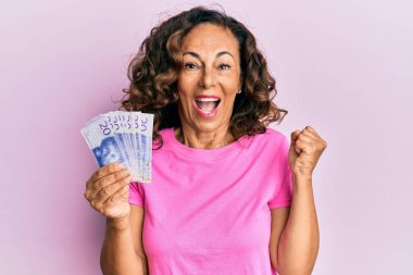 Orta yaşlı İspanyol kadın elinde İsveç banknotlarıyla gururla bağırıyor zaferi ve başarıyı kutluyor. 