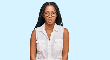 Güzel İspanyol kadın gündelik kıyafetler ve gözlük takıyor. Şaşırmış ve korkmuş bir ifade, korku ve heyecanlı bir yüz ifadesi var.. 