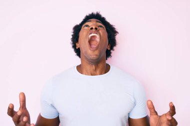 Yakışıklı Afro saçlı, sıradan giyinmiş, deli gibi bağıran, agresif ifade ve kollarıyla bağıran afro-amerikalı bir adam. hüsran kavramı. 