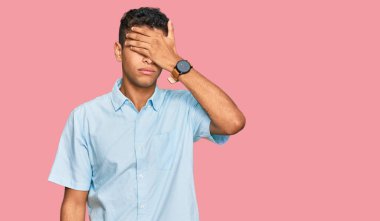 Genç, yakışıklı, Afro-Amerikan bir adam, günlük kıyafetler giyiyor, gözleri elle örtüyor, ciddi ve üzgün görünüyor. Görme, saklama ve reddetme konsepti 