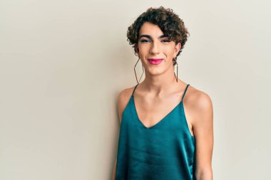 Makyaj yapan genç transseksüel bir adam ve kadın giysileri, moda ve göz kamaştırıcı görünüyor.