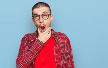 Gündelik kıyafetler giyen İspanyol genç adam inançsızlıktan, şaşkınlıktan ve elleri çenesinde şaşkınlıktan büyülenmiş gibi görünüyor. 