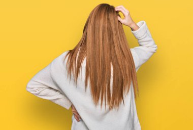 Kış süveterini ters giyen genç İrlandalı kadın elleri kafasında şüpheyi düşünüyor. 