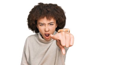 Kışın yün kazak giyen genç İspanyol kız kameraya kızgın ve sinirli bir şekilde seni işaret ediyor. 