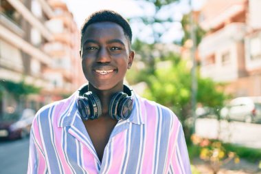 Şehrin caddesinde yürüyen, kulaklık takan Afrikalı genç bir Amerikalı..