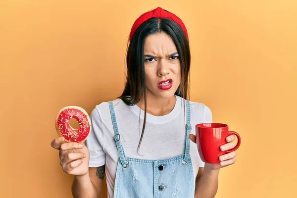 Menina Hispânica Jovem Comer Donut Beber Café Sem Noção Expressão — Fotografia de Stock