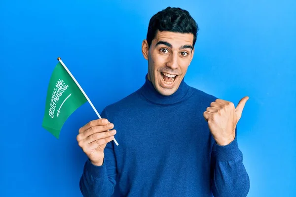 Snygg Latinamerikansk Man Som Håller Kungadömet Saudiarabiens Flagga Pekar Tummen — Stockfoto