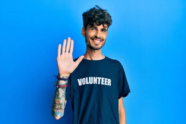 Gönüllü Tişört Giyen Genç Spanyol Adam Merhaba Diyor Mutlu Gülümseyen — Stok fotoğraf