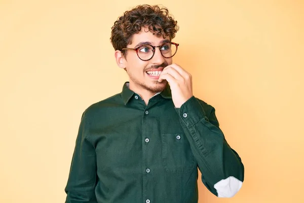 カジュアルな服や眼鏡を身に着けている巻き毛を持つ若い白人男性は 口の爪をかむ上で手で強調し 緊張している 不安の問題 — ストック写真