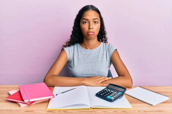 Young african american girl accountant working at the office depressed and worry for distress, crying angry and afraid. sad expression.