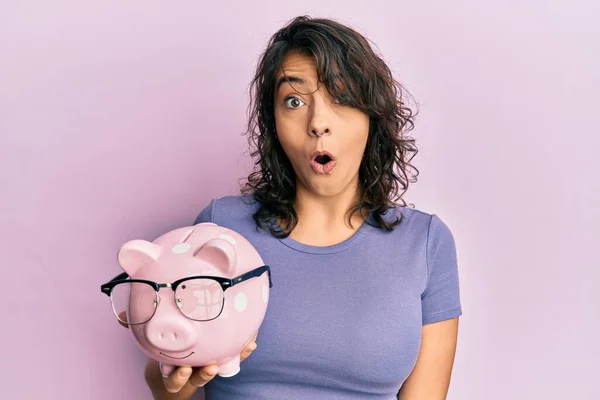 Young Hispanic Woman Holding Piggy Bank Glasses Scared Amazed Open — Stock Photo, Image