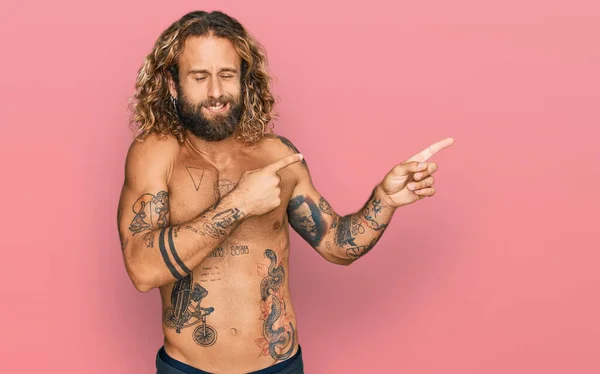 Pohledný Muž Vousy Dlouhými Vlasy Bez Trička Ukazující Tetování Ukazuje — Stock fotografie