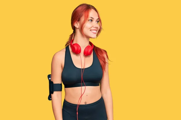 Genç Kızıl Saçlı Kadın Spor Kıyafetleri Giyiyor Kulaklık Takıyor Yüzünde — Stok fotoğraf